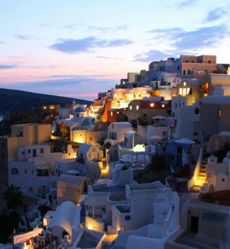 Casas blancas con cúpulas azules en Santorini, Grecia, con vistas al mar Egeo. Un destino popular en Europa para una escapada inolvidable