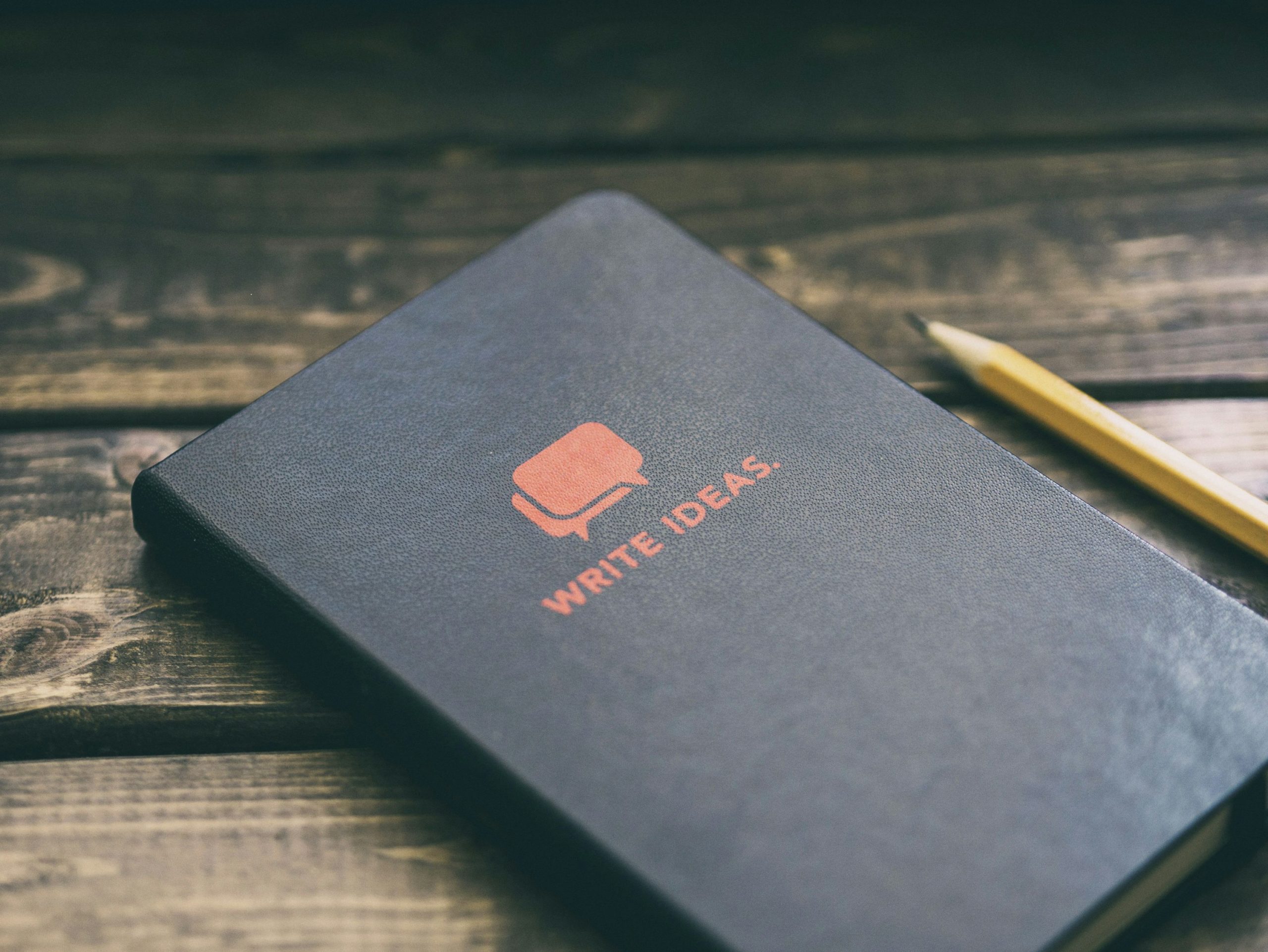 Escribir libro de ideas en una pizarra de madera marrón
