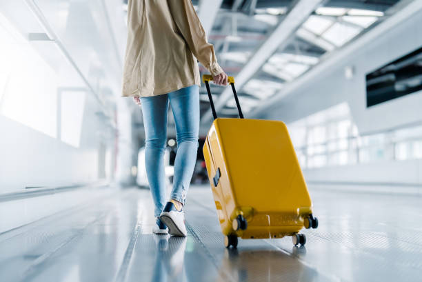 terminal dell'aeroporto internazionale. bella donna asiatica con i bagagli e a piedi in aeroporto - aeroporto foto e immagini stock